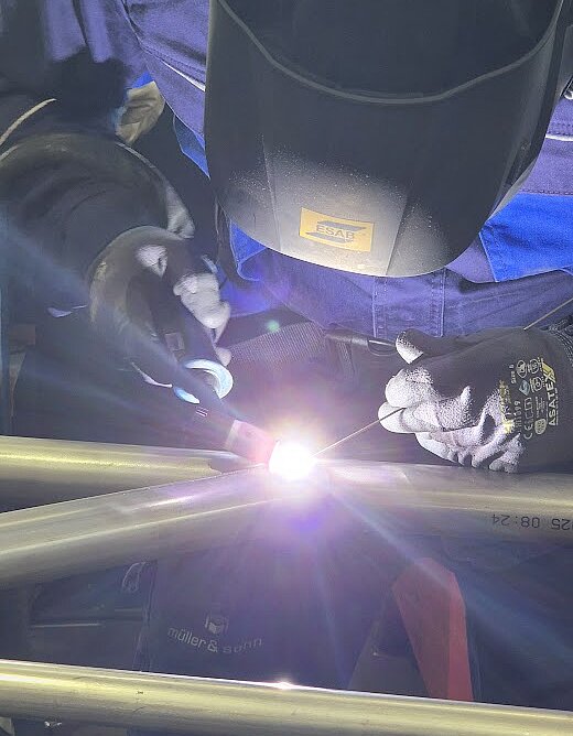 WIG-Schweißer mit Helm, der gerade am schweißen ist. 